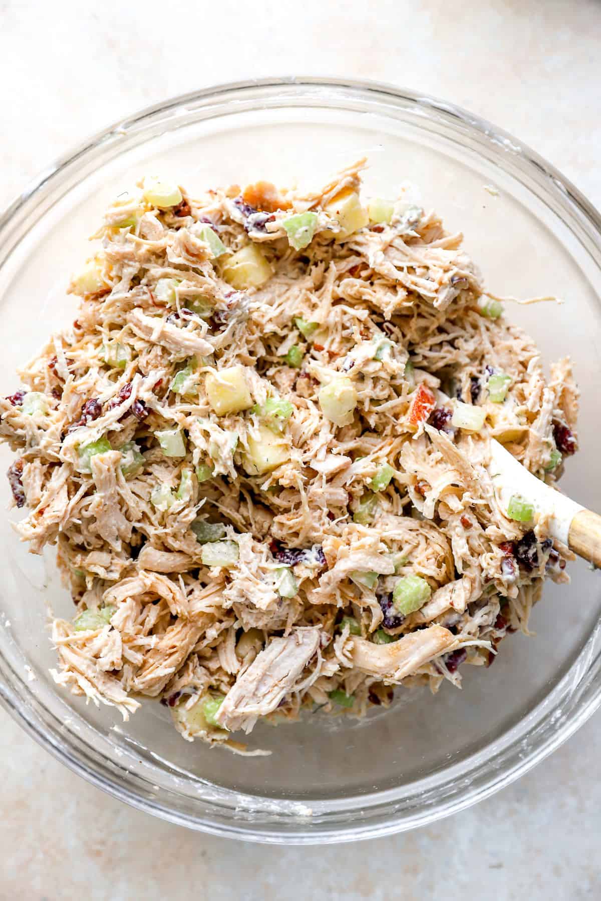 Harvest chicken salad ingredients being stirred in a bowl.