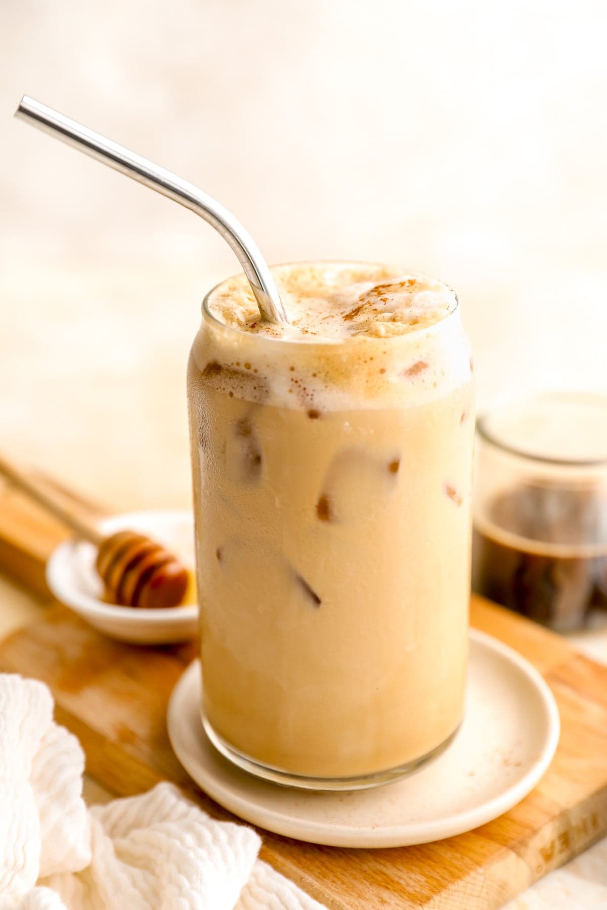 A whipped espresso sea salt latte in a glass with a metal straw sticking out.